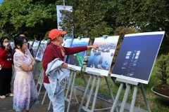 Khách du lịch quốc tế tham quanTriển lãm ảnh "Chuyện làng biển" tại ngày hội. (Ảnh: Trần Lê Lâm/TTXVN)