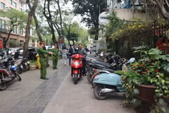 Công an phường Phan Chu Trinh (Hoàn Kiếm) nhắc nhở chủ cơ sở kinh doanh không được đỗ xe trên vỉa hè đường Lý Thường Kiệt. (Ảnh: Mạnh Khánh/TTXVN)