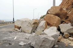 Những tảng đá lớn lăn từ trên núi xuống chắn ngang mặt đường. (Ảnh: Công Thử/TTXVN)