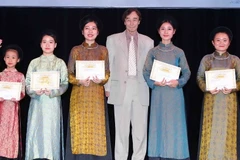 Giáo sư Odon Vallet trao Giấy chứng nhận và học bổng Vallet cho các em học sinh có thành tích xuất sắc trong học tập. (Ảnh: Quý Trung/TTXVN)