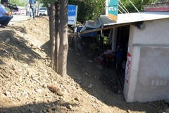 Ngôi nhà của ông Đoàn Trọng Kính thấp hơn 3m so với mặt Quốc lộ 1A. (Ảnh: Trịnh Bang Nhiệm/TTXVN)