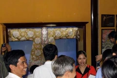 Khách tham quan trang phục đại triều của Hoàng Thái hậu. (Ảnh: Quốc Việt/Vietnam+)