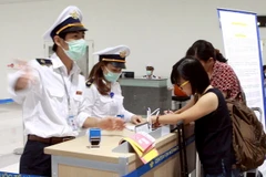 Hành khách từ Hàn Quốc nhập cảnh đến Việt Nam thực hiện kê khai tờ khai y tế. (Ảnh: Dương Ngọc/TTXVN)