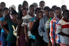 Người di cư xếp hàng nhận đồ ăn trên tàu Hải quân Đức sau khi được cứu vớt trên biển Địa Trung Hải ngày 27/9. (Nguồn: AFP/TTXVN)