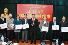 Ông Trương Minh Tuấn, Thứ trưởng Bộ Thông tin và Truyền thông trao chứng chỉ hành nghề biên tập cho biên tập viên các Nhà xuất bản. (Ảnh: Minh Quyết/TTXVN)