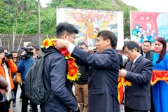 Lãnh đạo thành phố Móng Cái chào đón du khách thứ 1 triệu, ông Lâm Bân, du khách Trung Quốc. (Nguồn: mongcai.gov.vn)