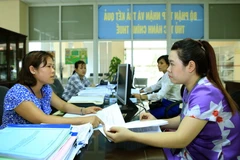 Tư vấn cho người nộp thuế tại bộ phận một cửa cục thuế Thái Nguyên. (Ảnh: Hoàng Hùng/TTXVN)