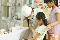 Mô hình y tế trường học góp phần tích cực trong việc chăm sóc sức khỏe ban đầu cho các học sinh tham gia BHYT. (Ảnh: Dương Ngọc/TTXVN)