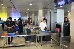 Hành khách làm thủ tục kiểm tra soi chiếu an ninh tại Cảng hàng không. (Ảnh: Việt Hùng/Vietnam+)