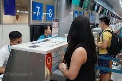 Hành khách mua vé máy bay của Vietnam Airlines. (Ảnh: Việt Hùng/Vietnam+)