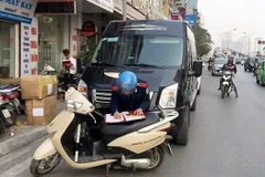 Thanh tra giao thông tiến hành lập biên bản xe Limousine dừng đỗ, đón trả khách sai quy định. (Ảnh: Đức Hùng/Vietnam+)
