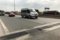 Một số khe con giãn trên cầu bong tróc, xuất hiện ổ gà nham nhở khiến mất an toàn giao thông. (Ảnh: Nguyễn Hằng/Vietnam+)