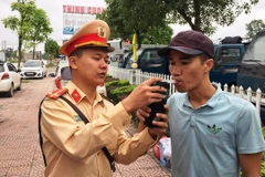 Cảnh sát giao thông tiến hành kiểm tra đo nồng độ cồn đối với lái xe. (Ảnh: Việt Hùng/Vietnam+)