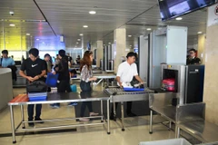 Hành khách làm thủ tục kiểm tra soi chiếu an ninh tại Cảng hàng không. (Ảnh: Việt Hùng/Vietnam+)
