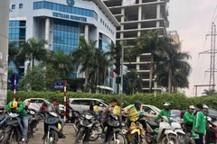Tài xế xe ôm khi hành nghề tại Hà Nội phải được cấp phép và đeo thẻ hành nghề trên ngực áo. (Ảnh: Hoài Thu/Vietnam+)
