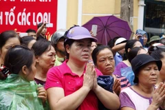 Người dân hai bên đường xúc động tiến đưa 9 liệt sỹ phi hành đoàn CASA-212. (Ảnh: Minh Sơn/Vietnam+)