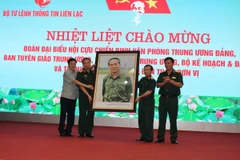 Đại diện Hội Cựu chiến binh 5 cơ quan Trung ương trao tặng phẩm cho Bộ tư lệnh Thông tin liên lạc. (Ảnh: Hùng Võ/Vietnam+)