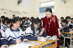 Giáo viên giúp học sinh ôn tập kiến thức. (Ảnh: Bích Huệ/TTXVN)