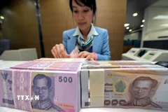 Nhân viên ngân hàng kiểm đếm đồng Baht tại Bangkok, Thái Lan. (Ảnh: AFP/TTXVN)