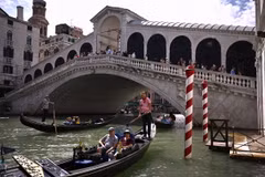 Khách du lịch đi thuyền gondola tại Venice, Italy. (Ảnh: AFP/TTXVN)