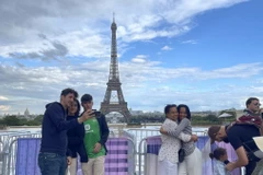 Người dân và khách du lịch chụp ảnh kỷ niệm từ xa do quảng trường Trocaderon và cầu Lena dẫn sang tháp Eiffel đã được trưng dụng cho các hoạt động của Thế vận hội Olympic. (Ảnh: Thu Hà/TTXVN)