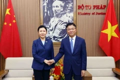 Bộ trưởng Tư pháp Lê Thành Long với Bộ trưởng Tư pháp Trung Quốc Hạ Vinh. (Ảnh: Phạm Kiên/TTXVN)