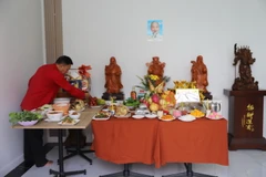 Ông Hòa cẩn thận bày biện bàn lễ cúng ông Công ông Táo. (Ảnh: Đỗ Sinh/TTXVN)