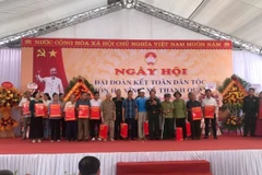 Thượng tướng Trịnh Văn Quyết trao quà cho các hộ gia đình có hoàn cảnh khó khăn tại ngày hội. (Ảnh: TTXVN phát)