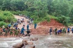 Các lực lượng san lấp, bồi đắp các đoạn bị hư hỏng, xói lở sau bão số 4. (Ảnh: TTXVN phát)