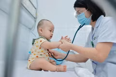 Bác sỹ khám cho bệnh nhi điều trị bệnh tay chân miệng. (Ảnh: Minh Quyết/TTXVN)