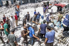 Người dân tìm kiếm nạn nhân dưới đống đổ nát của một trường học bị phá hủy sau cuộc không kích của Israel xuống Dải Gaza. (Ảnh: THX/TTXVN)