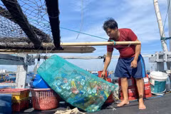 Ngư dân Võ Quốc Nguyện, thuyền trưởng tàu cá PY-90945 thực hiện việc đem rác thải về bờ sau mỗi chuyến biển. (Ảnh: Tường Quân/TTXVN)