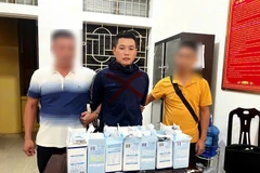 Đối tượng Nguyễn Văn Ba (giữa) (sinh năm 1993, trú tại xã Quỳnh Giang, huyện Quỳnh Lưu, tỉnh Nghệ An) cùng 9,3 kg ketamin tại cơ quan công an. (Ảnh: TTXVN phát)