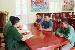 Lực lượng chức năng lấy lời khai của các đối tượng tổ chức chở người khác nhập cảnh trái phép. (Ảnh: TTXVN phát)