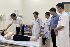 Ông Lê Hồng Trung, Giám đốc Sở Y tế tỉnh Vĩnh Phúc thăm hỏi, kiểm tra tình hình sức khỏe công nhân bị ngộ độc thực phẩm đang được điều trị tại Bệnh viện đa khoa tỉnh Vĩnh Phúc. (Ảnh: TTXVN phát)