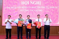 Bí thư Tỉnh ủy Điện Biên Trần Quốc Cường (phải) và Chủ tịch Hội đồng Nhân dân tỉnh Điện Biên Lò Văn Phương trao Quyết định và hoa chúc mừng các đồng chí được bổ nhiệm vị trí công tác mới. (Ảnh: Trung Kiên/TTXVN)