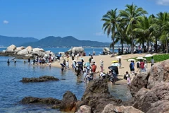 Khách du lịch tham quan một danh lam thắng cảnh ở Tam Á, tỉnh Hải Nam, Trung Quốc,. (Ảnh: THX/TTXVN)