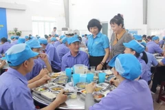 Lãnh đạo Liên đoàn Lao động Khánh Hòa thăm hỏi công nhân, đoàn viên công đoàn của Công ty In bao bì Khatoco trong "Bữa cơm Công đoàn." (Ảnh: Phan Sáu/TTXVN)