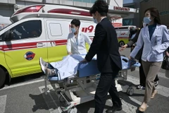 Nhân viên y tế Hàn Quốc chuyển bệnh nhân vào bệnh viện tại Seoul. (Ảnh: AFP/TTXVN)