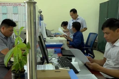Bí thư Đảng ủy xã Hát Lừu Giàng A Tặng kiểm tra cán bộ một cửa thực hiện quy trình tiếp nhận và trả kết quả cho người dân. (Ảnh: TTXVN phát)