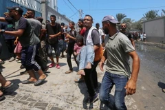 Chuyển em nhỏ bị thương sau cuộc không kích của Israel nhằm vào bệnh viện dã chiến trong trường học ở Deir al-Balah, Dải Gaza. (Ảnh: THX/TTXVN)