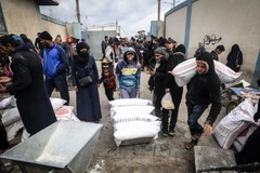 Người tị nạn Palestine nhận lương thực cứu trợ tại thành phố Rafah, Dải Gaza. (Ảnh: AFP/TTXVN)