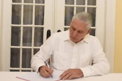 Bí thư thứ Nhất Ban Chấp hành Trung ương Đảng, Chủ tịch Cuba Miguel Díaz-Canel Bermúdez ghi sổ tang. (Ảnh: Việt Hùng/TTXVN)