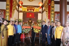 Đại sứ Phạm Việt Hùng, Tổng lãnh sự Chu Đức Dũng, cùng đại diện các hội kiều bào chụp ảnh lưu niệm trước ban thờ Bác Hồ. (Ảnh: Đỗ Sinh/TTXVN)