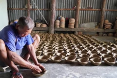 Người thợ kéo đường chỉ cho nồi đất. (Ảnh: Văn Sĩ/TTXVN)