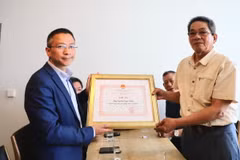 Tham tán Công sứ Chu Tuấn Đức tặng kỷ niệm chương ông Nguyễn Ngọc Chiến, thương binh tại chiến trường Quảng Trị. (Ảnh: Phương Hoa/TTXVN)