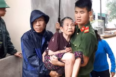 Lực lượng công an huyện Con Cuông giúp dân chuyển đến nơi an toàn. (Ảnh: Bá Hậu/TTXVN)