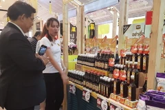 Khách Thái Lan tham quan gian hàng trưng bày. (Ảnh: Sơn Nam/TTXVN)