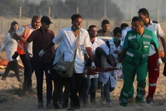 Chuyển người biểu tình Palestine bị thương tại khu vực biên giới Gaza- Israel ngày 3/8. (Ảnh: AFP/TTXVN)