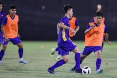 Văn Đức (áo cam) tranh bóng với Duy Mạnh (trái) tại buổi tập chiều 21/8. (Ảnh: Hoàng Linh/TTXVN)